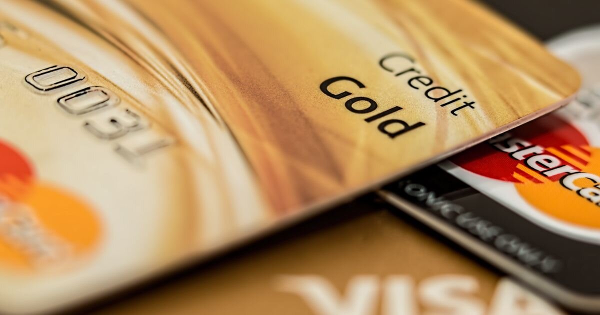 Stack of consumer credit cards fanned across a surface. Card balances and delinquency data in 2026