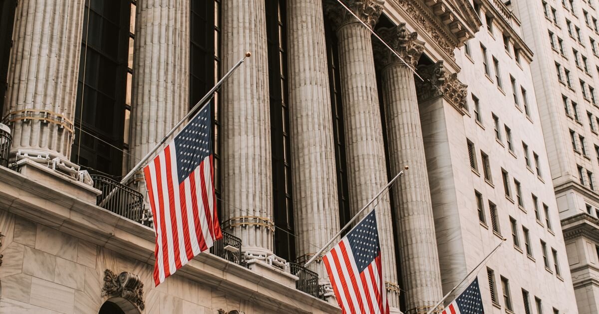 American flags draped over the New York Stock Exchange facade. Backdrop for 2026's record ETF inflows.